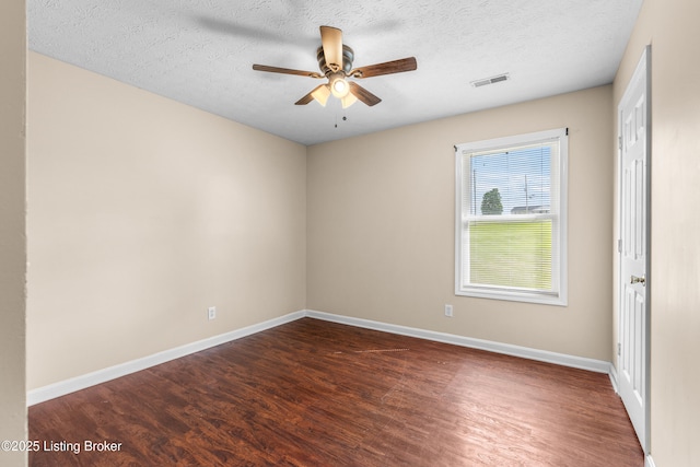 empty room featuring wood finished floors, ceiling fan, baseboards, and a textured ceiling