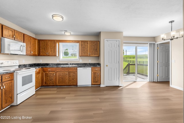 kitchen with white appliances, plenty of natural light, and brown cabinetry