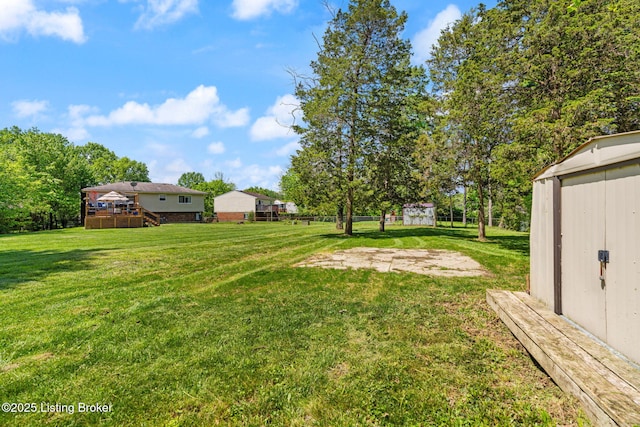 view of green lawn featuring a storage shed, an outbuilding, a deck, and stairway