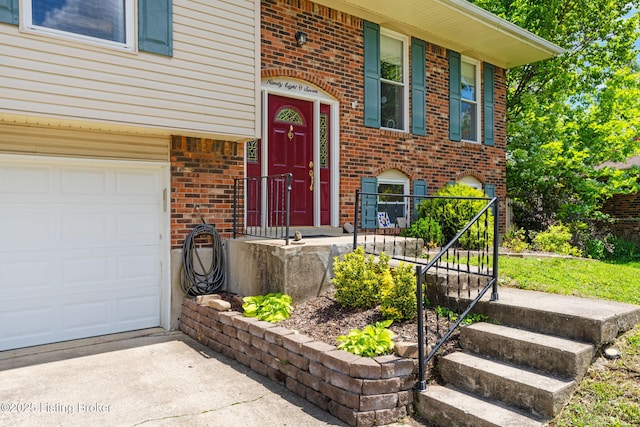 property entrance featuring brick siding, a garage, and concrete driveway