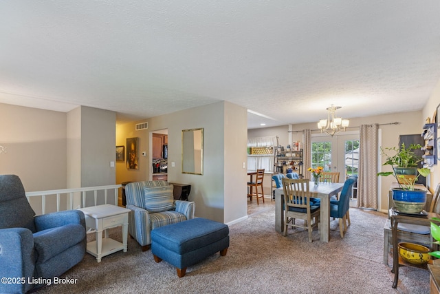 carpeted dining area with a chandelier and a textured ceiling