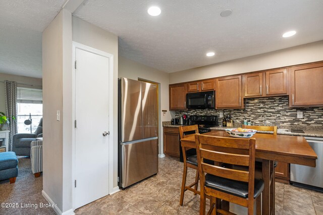 kitchen featuring black appliances, brown cabinets, backsplash, and recessed lighting