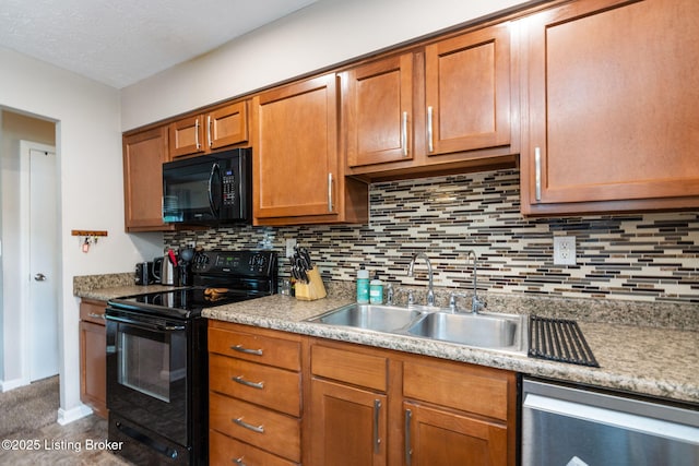 kitchen with black appliances, a sink, backsplash, light countertops, and brown cabinetry