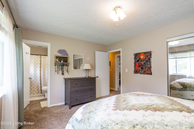 bedroom featuring carpet floors, a textured ceiling, connected bathroom, and baseboards