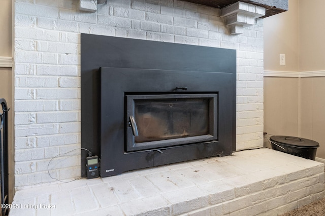 detailed view of a fireplace and a wainscoted wall