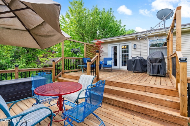 wooden terrace with french doors, outdoor dining space, and area for grilling