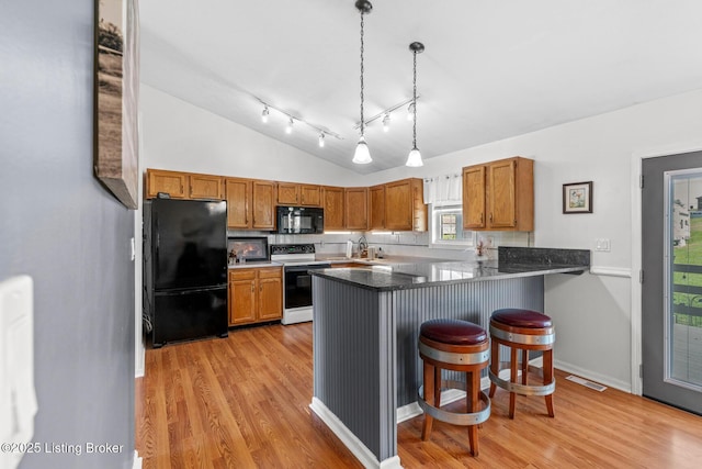 462 Wilsonville Rd, Fisherville, KY 40023 - kitchen featuring black appliances, brown cabinetry, light wood finished floors, a peninsula, and lofted ceiling