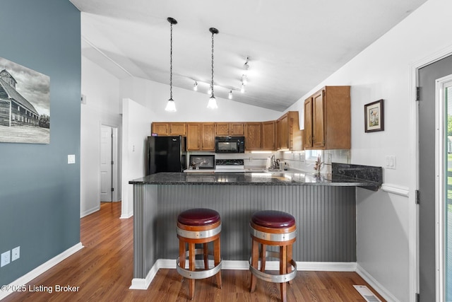 462 Wilsonville Rd, Fisherville, KY 40023 - kitchen featuring black appliances, a peninsula, brown cabinets, vaulted ceiling, and dark wood-style flooring