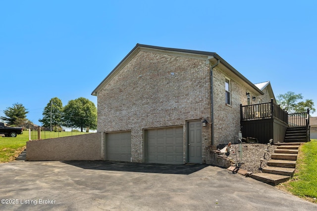 462 Wilsonville Rd, Fisherville, KY 40023 - view of home's exterior featuring stairway, a garage, brick siding, asphalt driveway, and a wooden deck