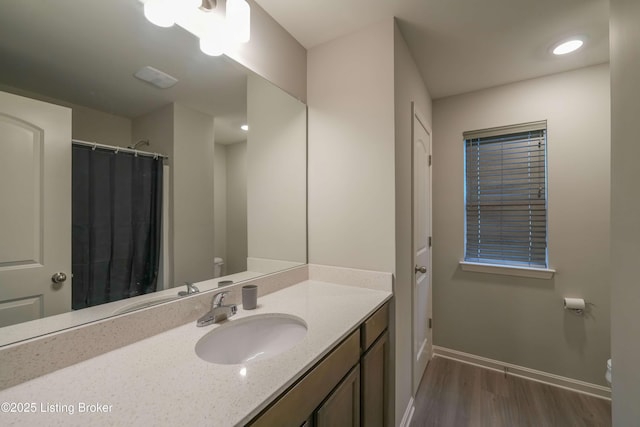 11905 Parkside Vista Ln, Louisville, KY 40229 - bathroom with toilet, wood finished floors, baseboards, and vanity