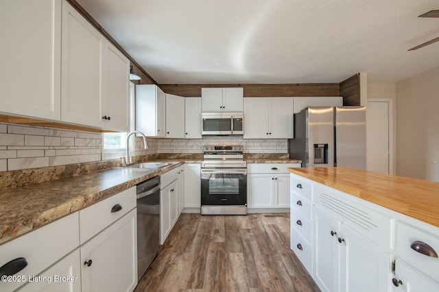 522 Lee Rd, Elizabethtown, KY 42701 - kitchen featuring stainless steel appliances, a sink, wood finished floors, white cabinetry, and tasteful backsplash