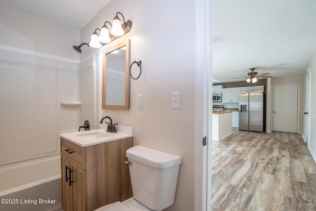 522 Lee Rd, Elizabethtown, KY 42701 - full bathroom with wood finished floors, ceiling fan, toilet, vanity, and bathing tub / shower combination
