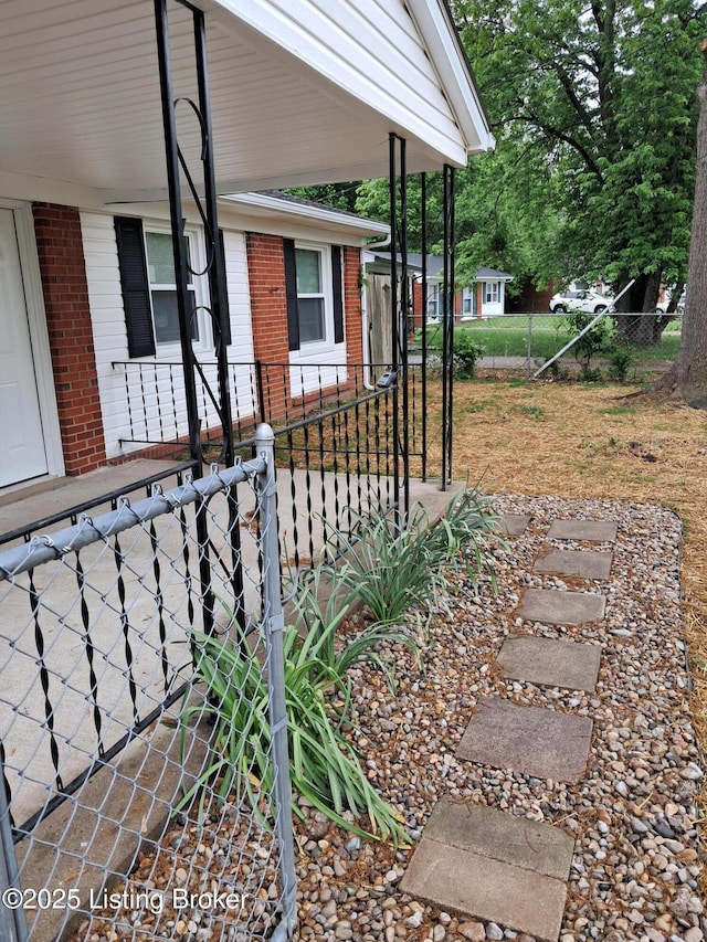 view of yard with covered porch and fence