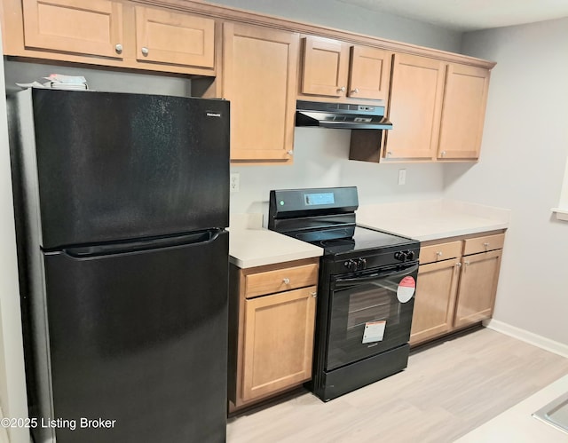 kitchen with black appliances, under cabinet range hood, light wood-style flooring, light countertops, and baseboards