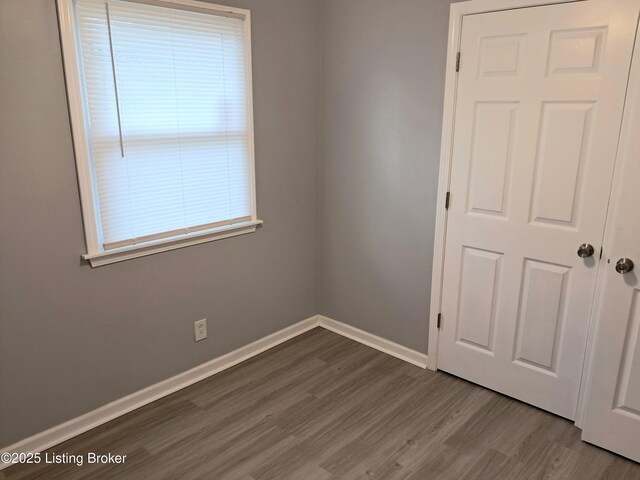 unfurnished room featuring wood finished floors and baseboards