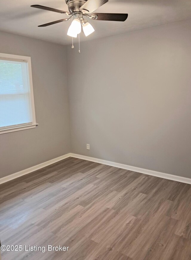 unfurnished room featuring wood finished floors, baseboards, and ceiling fan