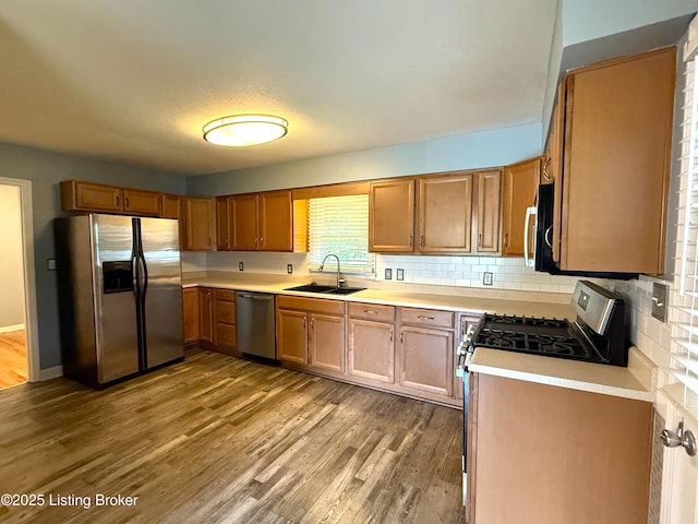 701 Dogwood Dr, Elizabethtown, KY 42701 - kitchen featuring appliances with stainless steel finishes, a sink, light countertops, wood finished floors, and tasteful backsplash