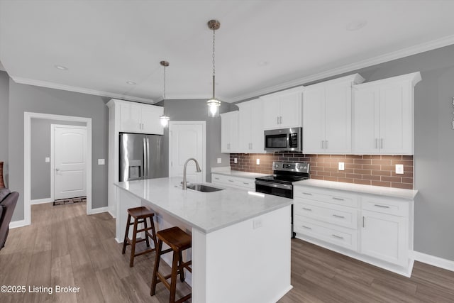 361 Williamsburg Dr, Mt Washington, KY 40047 - kitchen featuring appliances with stainless steel finishes, a sink, a center island with sink, a breakfast bar area, and decorative backsplash