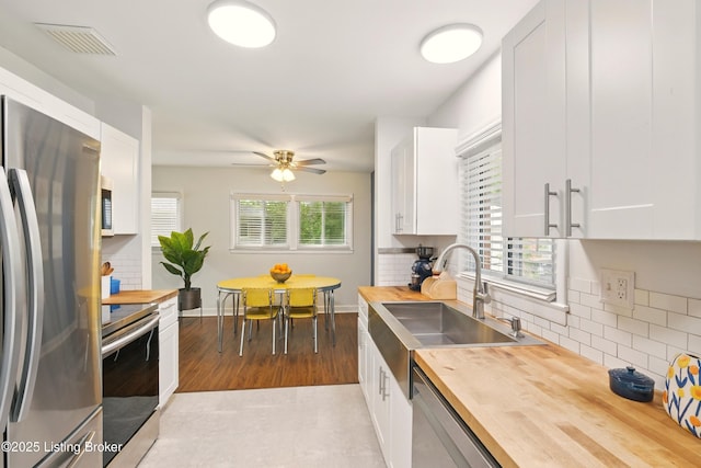 3113 Aires Ct, Louisville, KY 40220 - kitchen with butcher block countertops, stainless steel appliances, a sink, decorative backsplash, and white cabinets