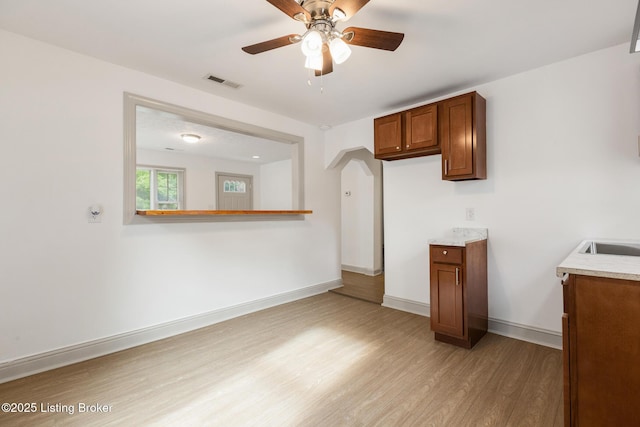 7802 Edna M Rd, Louisville, KY 40258 - kitchen featuring brown cabinetry, light wood finished floors, a ceiling fan, light countertops, and baseboards