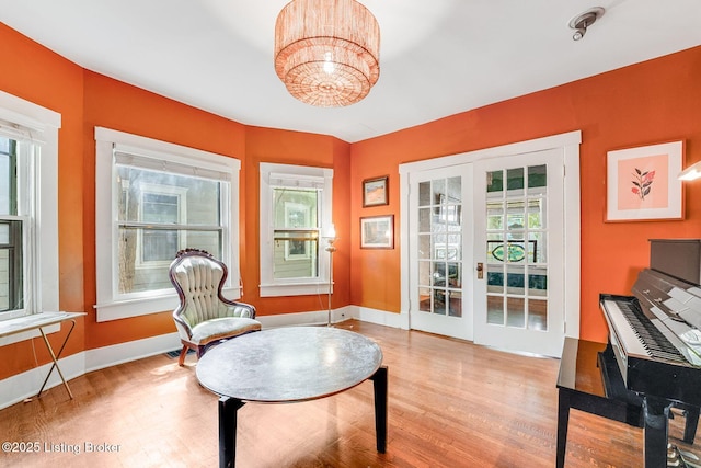 1830 Edgeland Ave, Louisville, KY 40204 - sitting room with healthy amount of natural light, wood finished floors, baseboards, and a chandelier