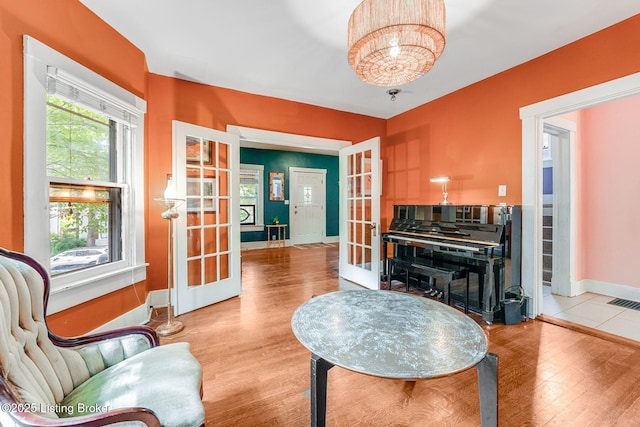 1830 Edgeland Ave, Louisville, KY 40204 - living area with french doors, a chandelier, wood finished floors, and baseboards