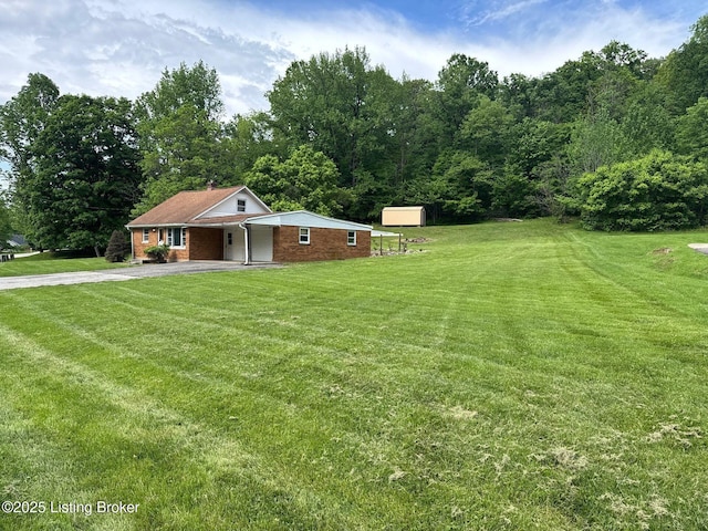 view of grassy yard with asphalt driveway