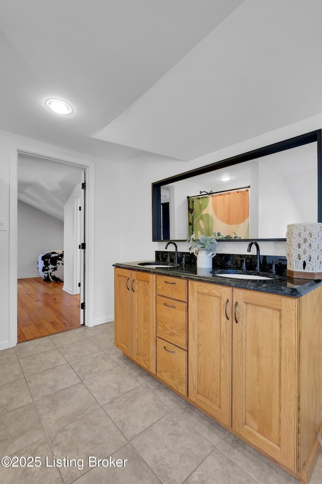 2410 Sherry Rd, Louisville, KY 40217 - kitchen featuring a sink, light tile patterned floors, recessed lighting, dark stone countertops, and baseboards
