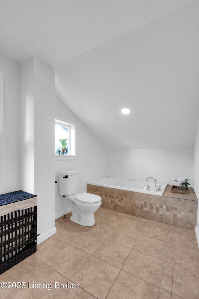 2410 Sherry Rd, Louisville, KY 40217 - bathroom with toilet, tiled bath, vaulted ceiling, tile patterned floors, and baseboards