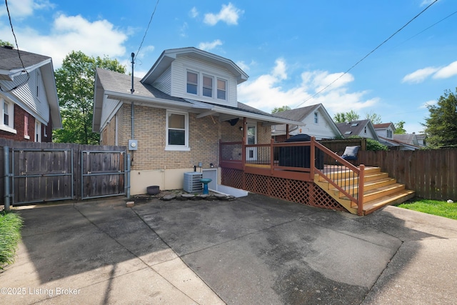 2410 Sherry Rd, Louisville, KY 40217 - view of front of house featuring a gate, brick siding, fence, a wooden deck, and central AC