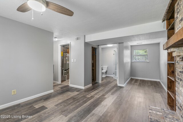 unfurnished living room with wood finished floors, ceiling fan, and baseboards
