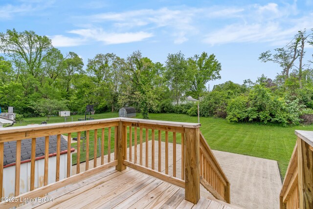 wooden terrace with a storage unit, an outbuilding, a yard, and view of scattered trees