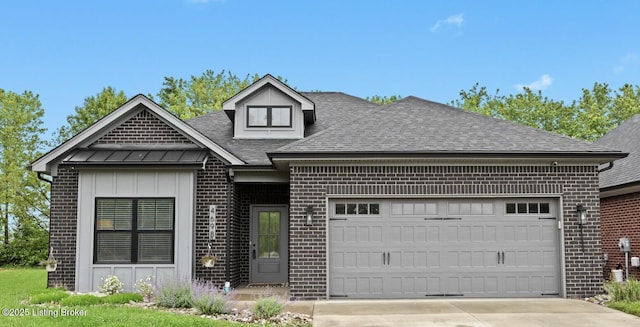 view of front of property featuring a garage, board and batten siding, brick siding, and a shingled roof