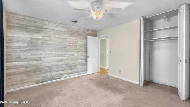 unfurnished bedroom with carpet, a closet, baseboards, and a ceiling fan