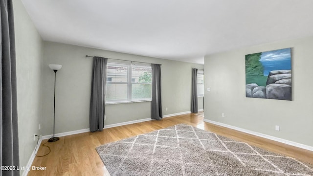 spare room with wood finished floors and baseboards