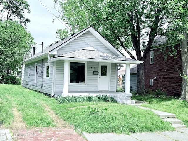 713 E Hill St, Louisville, KY 40217 - view of front of home with a porch, a shingled roof, and a front lawn
