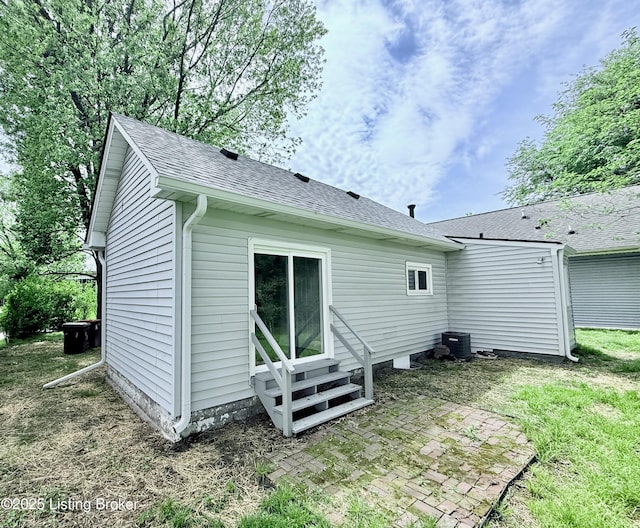 713 E Hill St, Louisville, KY 40217 - back of house featuring entry steps, roof with shingles, a patio area, and central AC