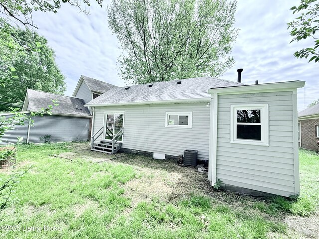 713 E Hill St, Louisville, KY 40217 - rear view of house featuring a lawn, a shingled roof, entry steps, and central air condition unit