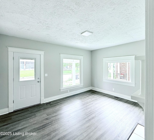 713 E Hill St, Louisville, KY 40217 - foyer entrance with dark wood finished floors, baseboards, and a textured ceiling