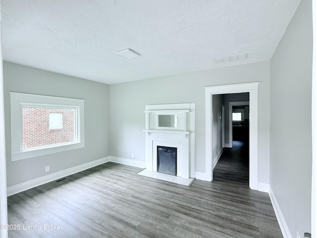 713 E Hill St, Louisville, KY 40217 - unfurnished living room featuring wood finished floors, a fireplace, a textured ceiling, and baseboards