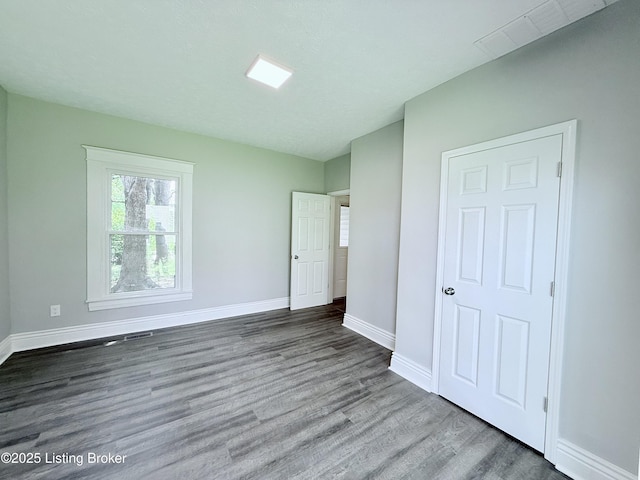 713 E Hill St, Louisville, KY 40217 - unfurnished bedroom featuring wood finished floors and baseboards