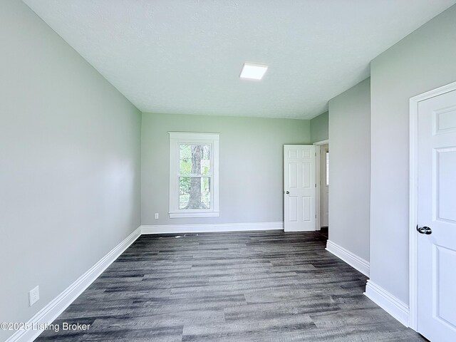 713 E Hill St, Louisville, KY 40217 - unfurnished bedroom with baseboards and dark wood-style floors