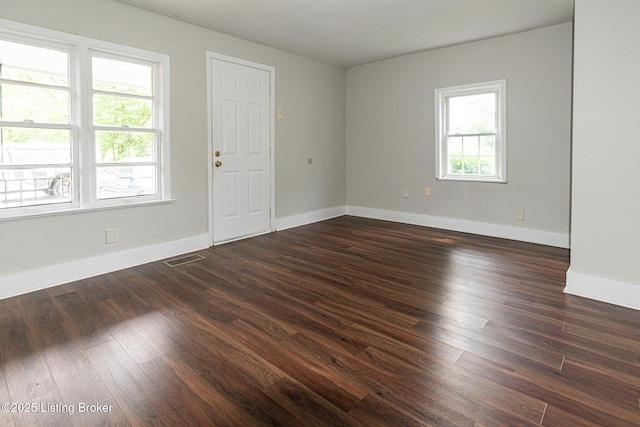 empty room featuring baseboards and dark wood-style flooring