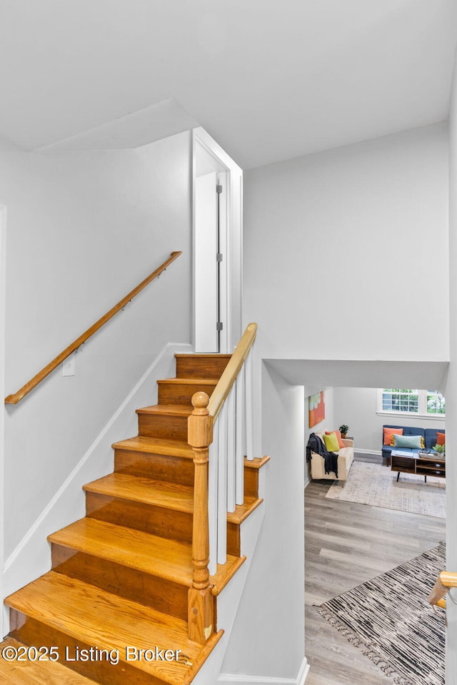 stairs with wood finished floors and baseboards