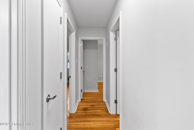 hall featuring wood finished floors and baseboards