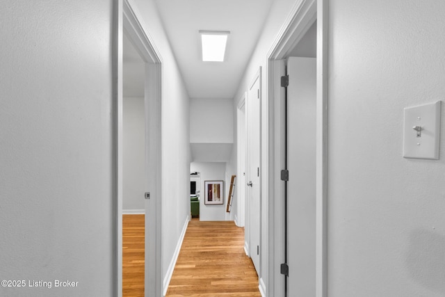 hallway with light wood-style flooring and baseboards