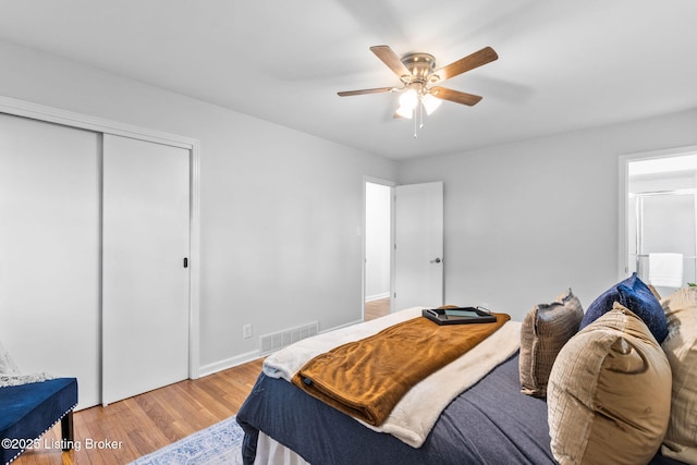 bedroom with wood finished floors, a closet, ceiling fan, and baseboards