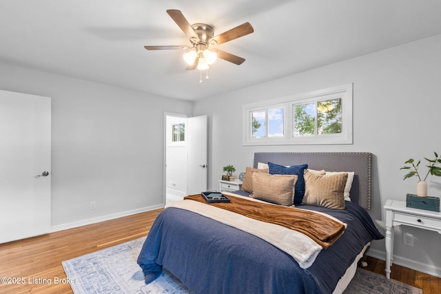 bedroom with wood finished floors, baseboards, and a ceiling fan