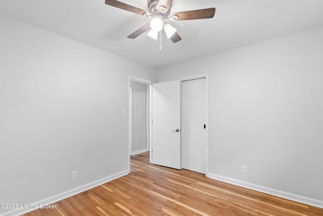 unfurnished bedroom featuring baseboards, light wood-style floors, ceiling fan, and a closet