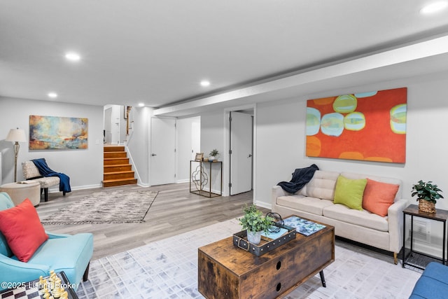 living area featuring recessed lighting, wood finished floors, baseboards, and stairway